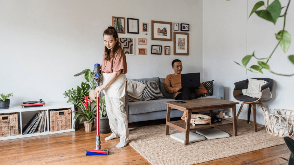 A man and woman working on laptop in living room