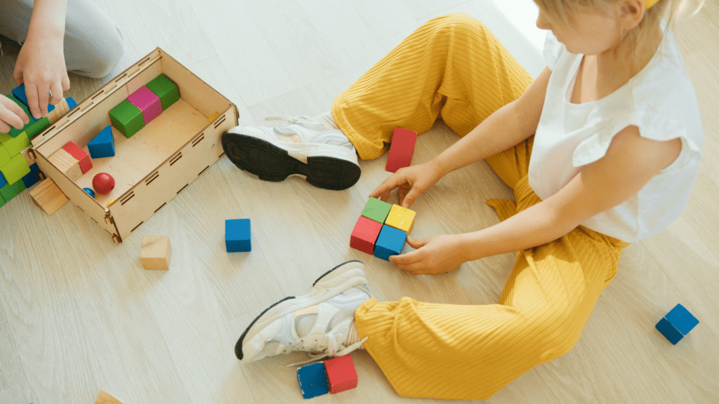 children playing with wooden blocks on the floor