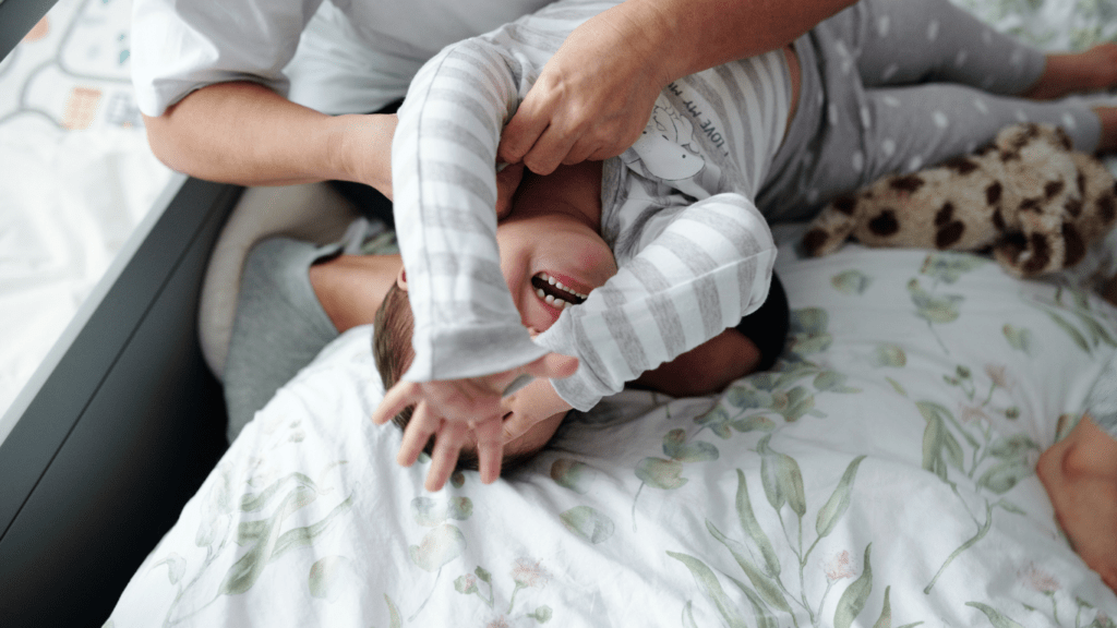 mother holding her baby on a bed