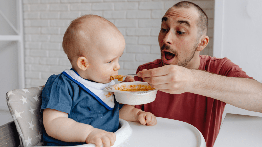 a baby in a high chair with a bowl of food