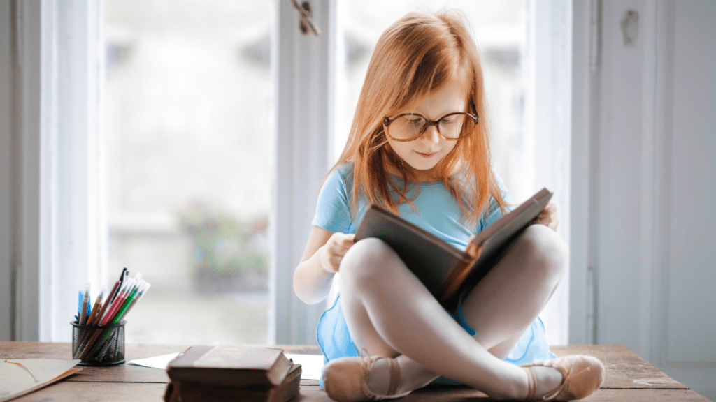 a child wearing glasses is reading a book