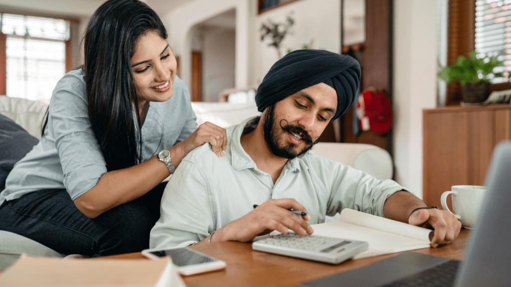 A man and woman working on laptop in living room