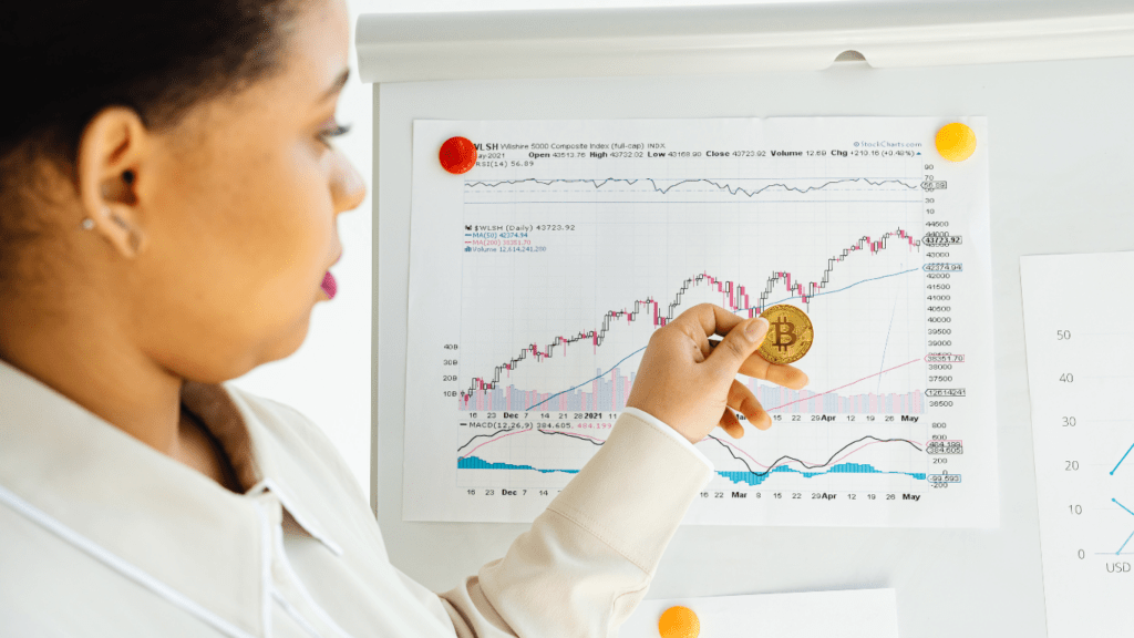 bitcoins on a table next to a stock chart