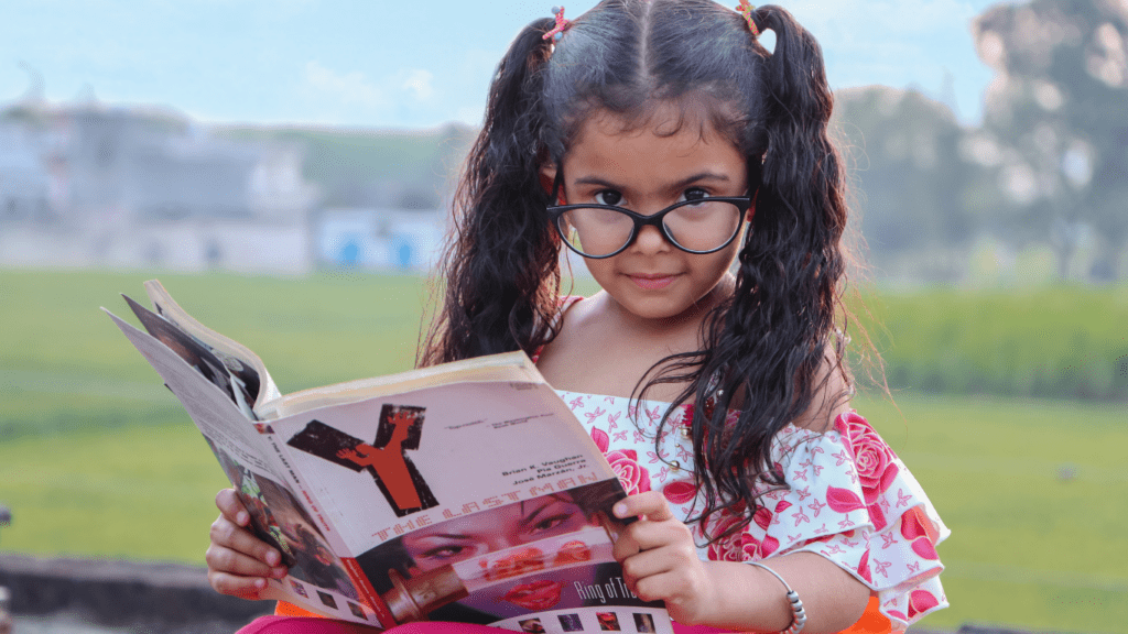 a child wearing glasses is reading a book