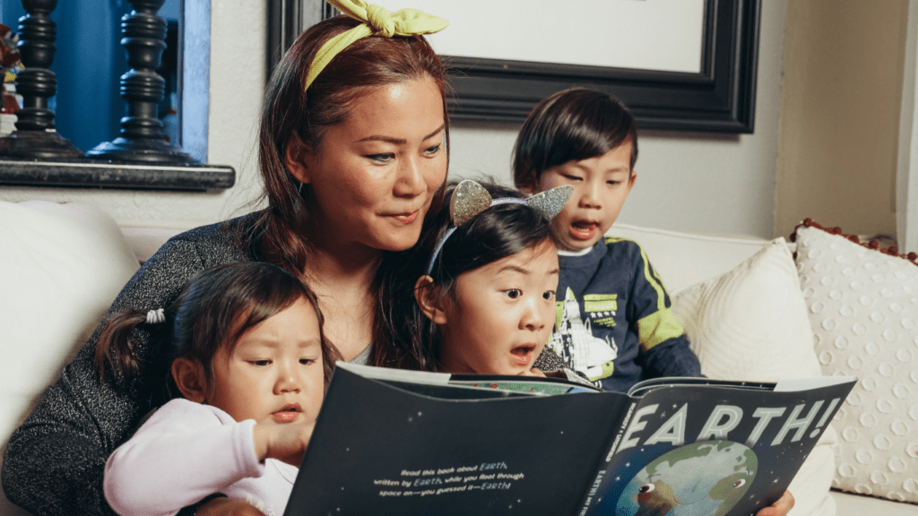 mother reading a book to her kids