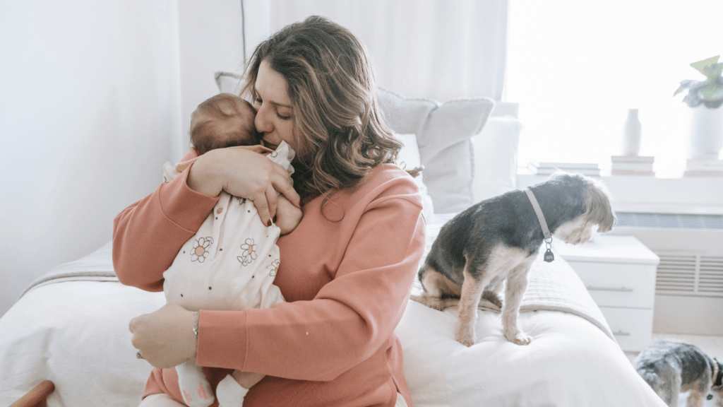 mother holding her baby on a bed 