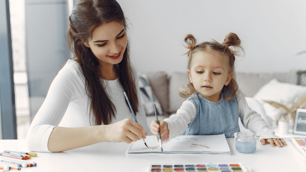 mother teaching her daughter on colored pencil