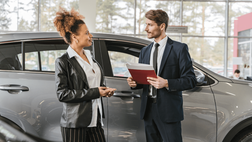 two people in a car dealership talking to each other