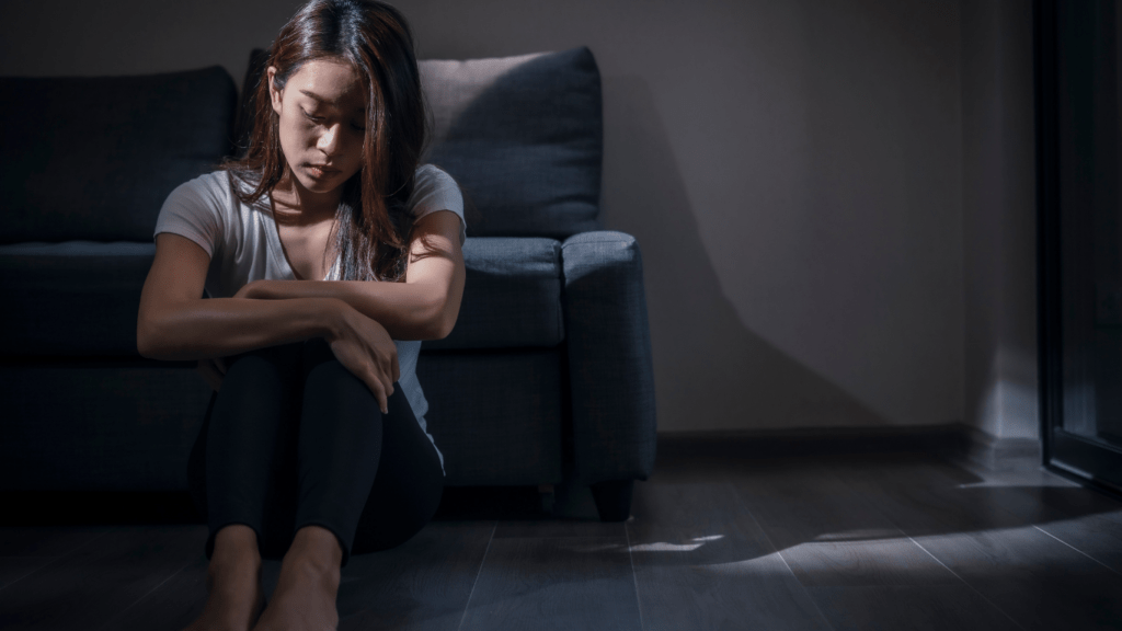 a person sitting on the floor in front of a couch